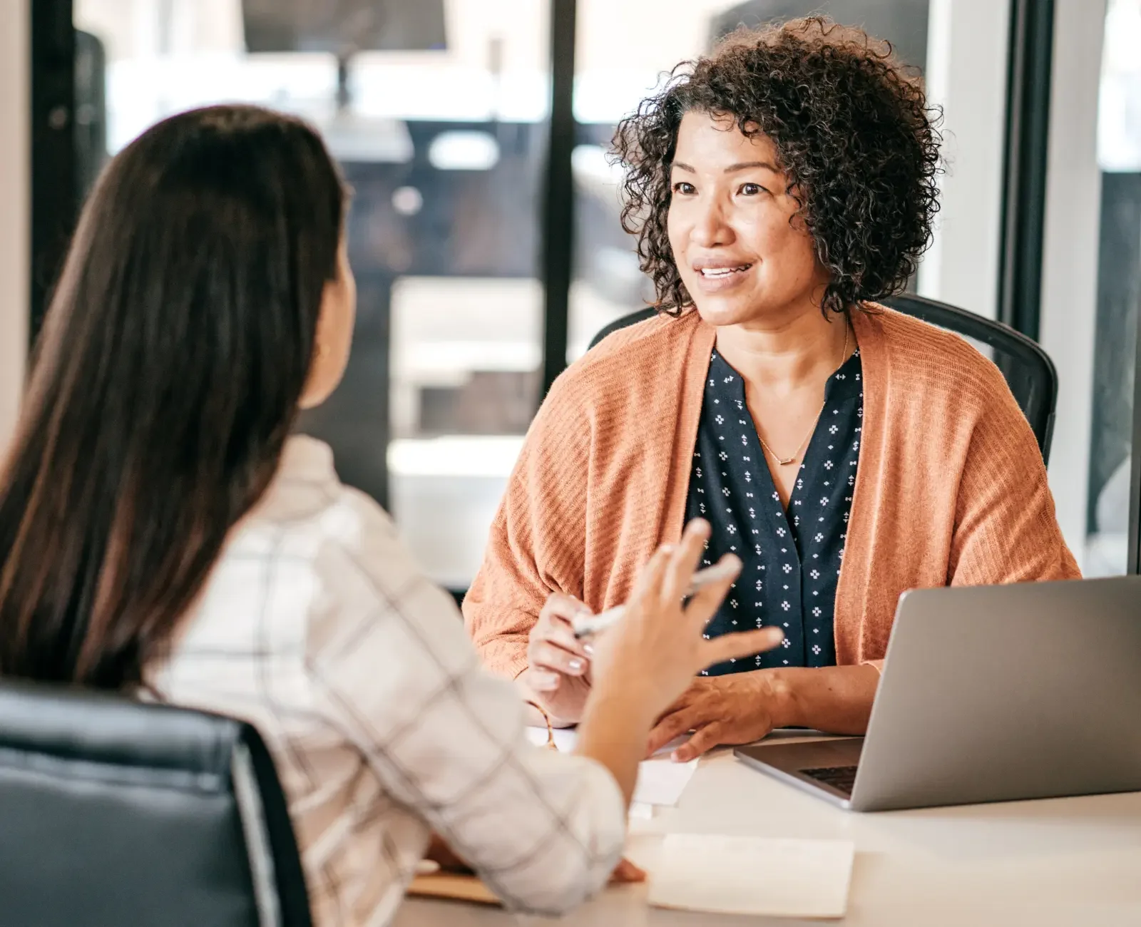 Professional woman consulting with a client in an office setting, demonstrating EOR in France. This image showcases a collaborative work environment, illustrating how employer of record services support professional interactions and business operations in France.