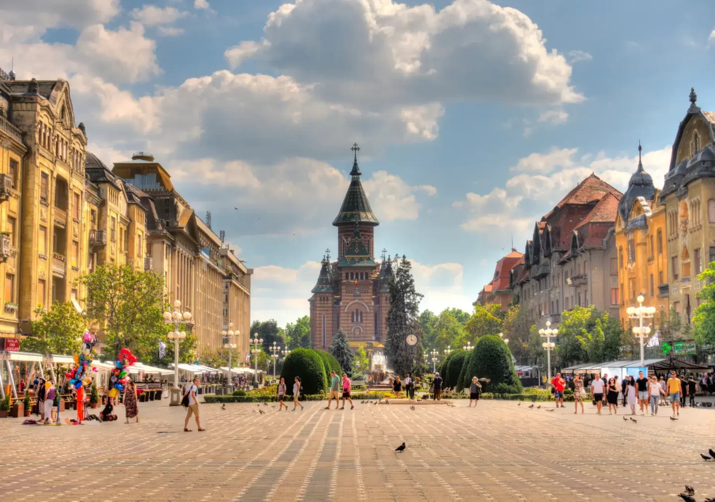 The picturesque central square of a Romanian city, showcasing historic buildings and bustling activity, representing the vibrant economic environment supported by EOR in Romania.