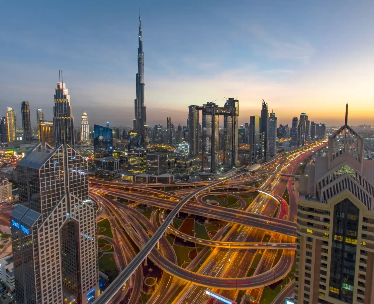 A stunning aerial view of Dubai's skyline at dusk, featuring the iconic Burj Khalifa and illuminated highways, representing EOR in UAE. The image highlights the modern and dynamic business environment of the United Arab Emirates, showcasing its impressive infrastructure and economic growth.