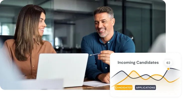 Two smiling professionals having a discussion in front of a laptop, with a chart showing incoming candidate statistics in the foreground.