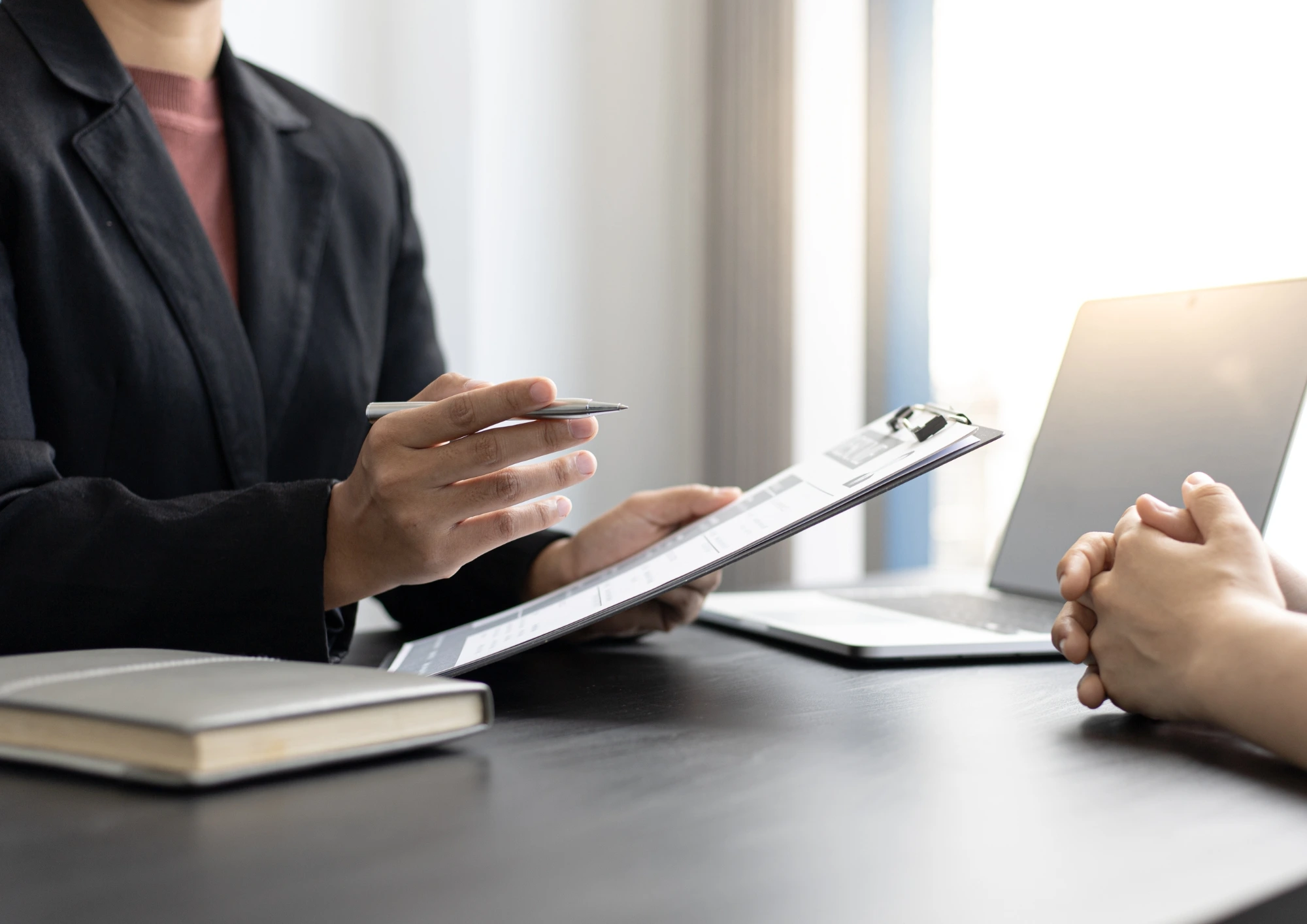 An job interview in progress. The recruiter is reviewing a candidate's resume