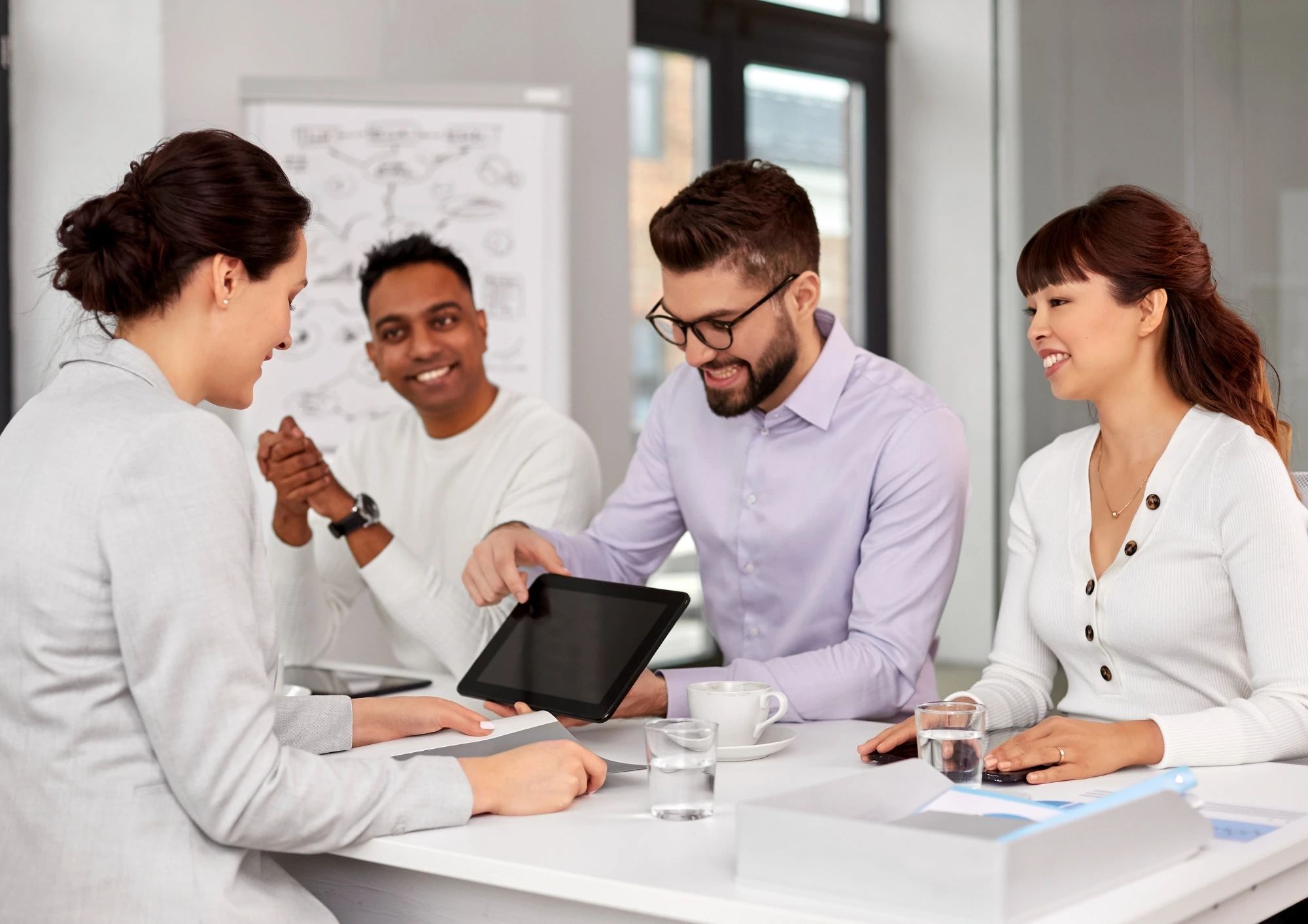 A team collaborates in the office to discuss ideas with a digital presentation