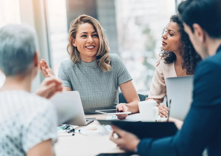 A group of professionals engage in a business discussion to share insights