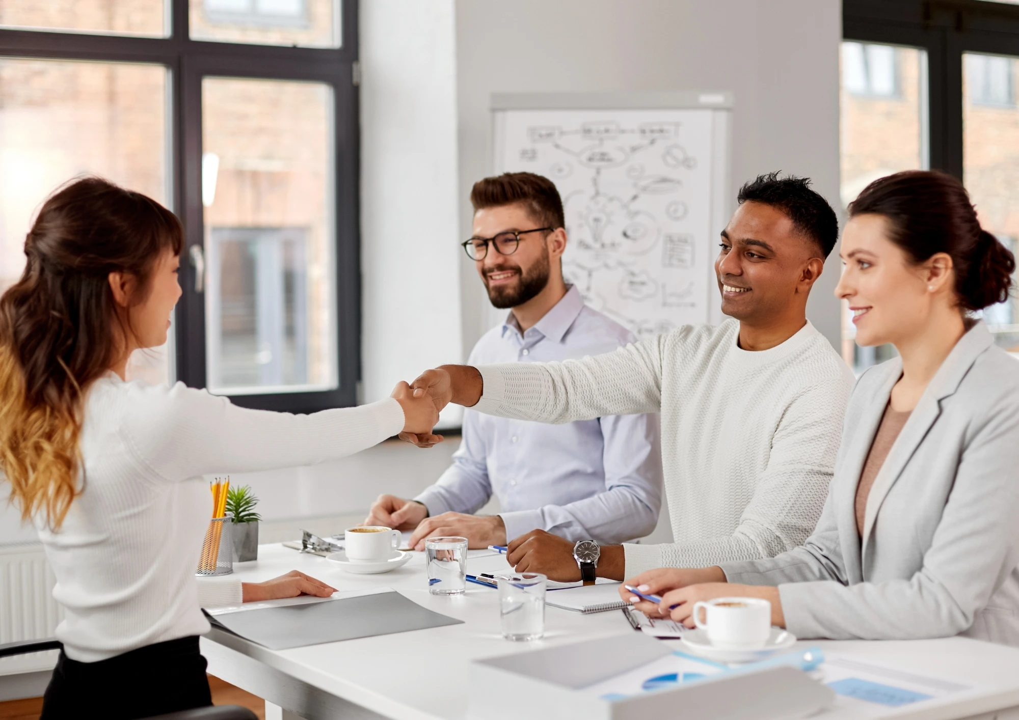 A successful job interview that the candidate and recruiter shake hands.in the meeting room